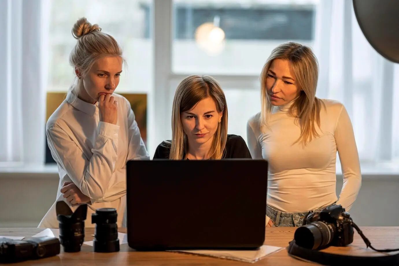 Front view of a photographer and models looking at photos.